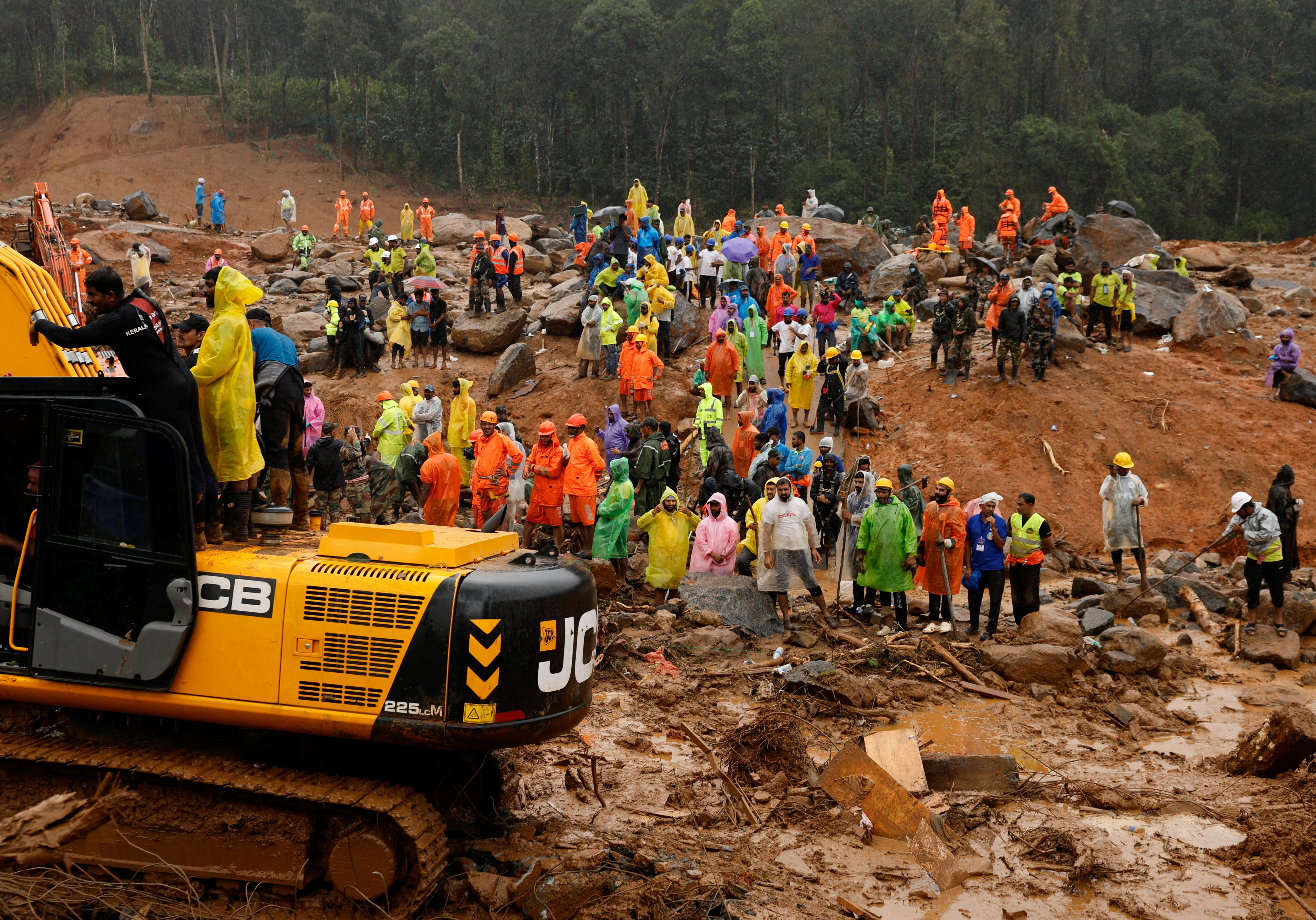 People watch as search operations are carried out after landslides hit Mundakkai village in Wayanad district in the southern state of Kerala